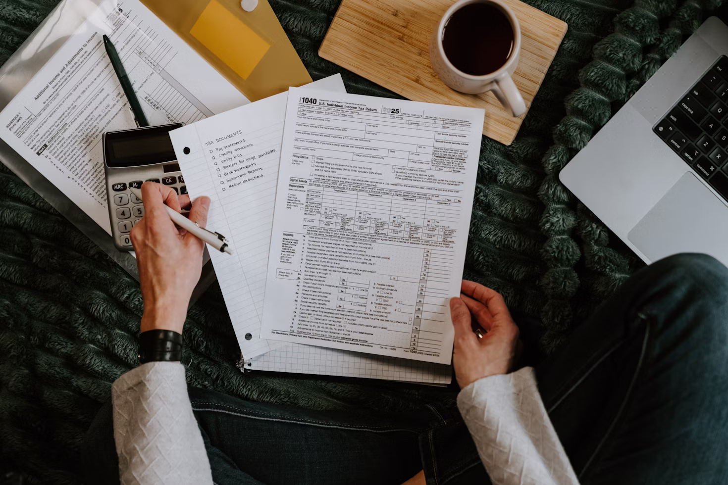 Person reviewing tax documents at a desk with a laptop, representing passive income tax education featured in Good Financial Cents