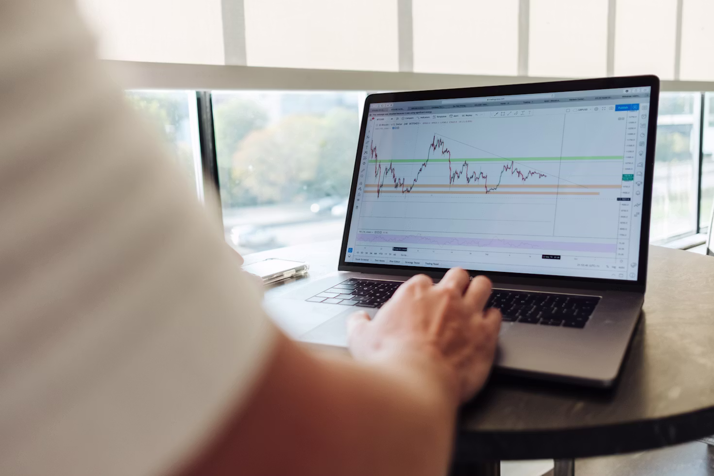Person analyzing investment portfolio on a laptop with a notepad, representing the decision between lump sum investing and dollar cost averaging